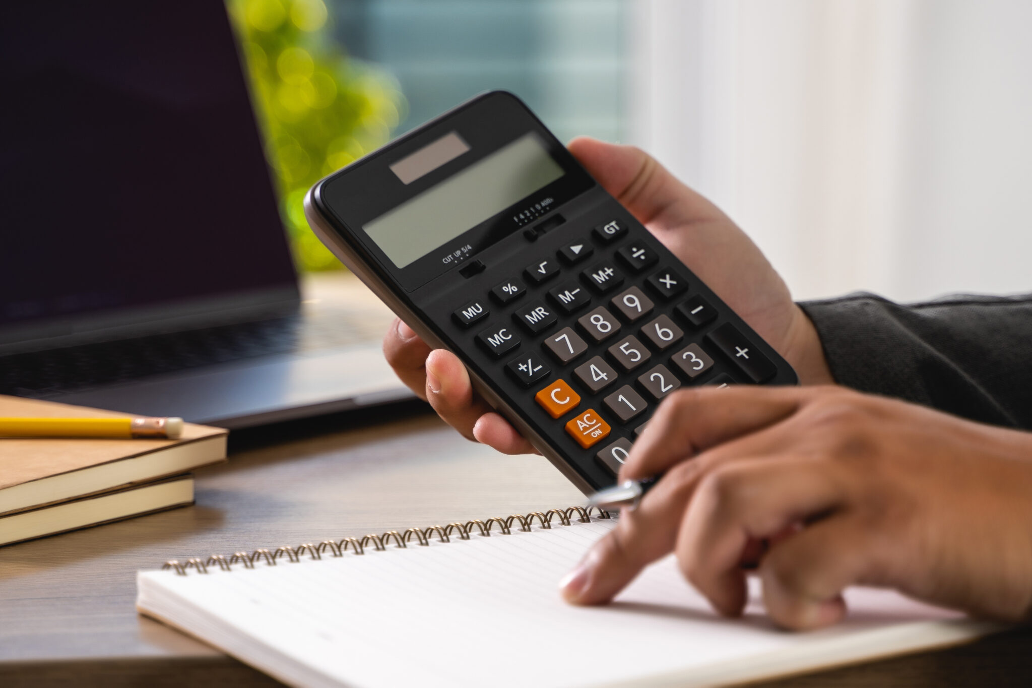 man calculating expenses on a calculator